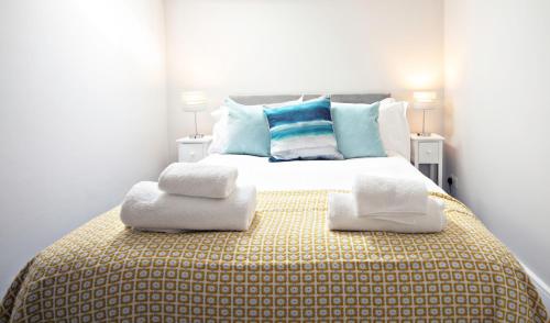 a bedroom with a large bed with towels on it at The Loft Apartment, 8 Granville Road in Harrogate