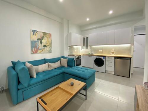 a living room with a blue couch and a kitchen at Luxury 1 Bedroom Flat in Athens