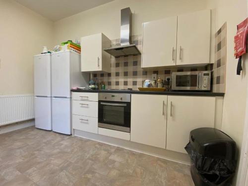 a kitchen with white appliances and white cabinets at Spacious Victorian Double Room 2 in Doncaster