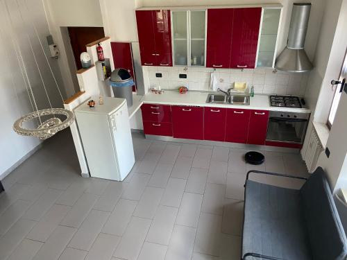 a kitchen with red cabinets and a white floor at Da Lumi Relax in Lanzo Torinese