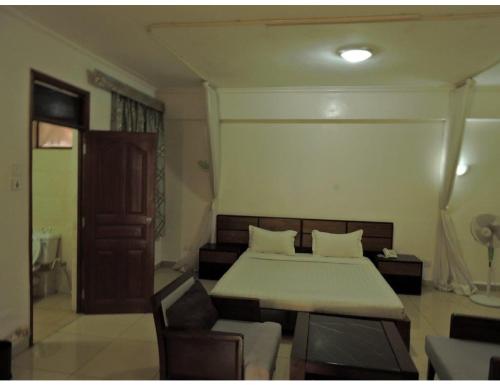 a bedroom with a bed and a table and chairs at Sky Hotel Nairobi in Nairobi