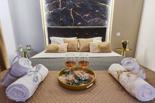 a bedroom with a bed with two glasses of wine at Voguish in Bucharest