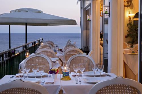 a table with wine glasses and a view of the ocean at Hotel Onda Verde in Praiano