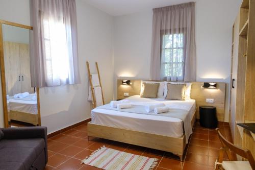 a bedroom with a large white bed and a couch at SANTA ANA studios in Nea Skioni