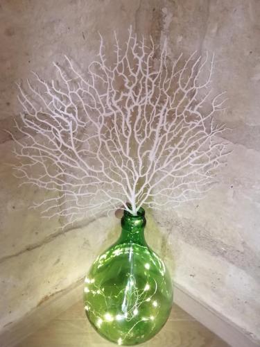 a green vase with a tree in it at Palazzo Emy in Lecce