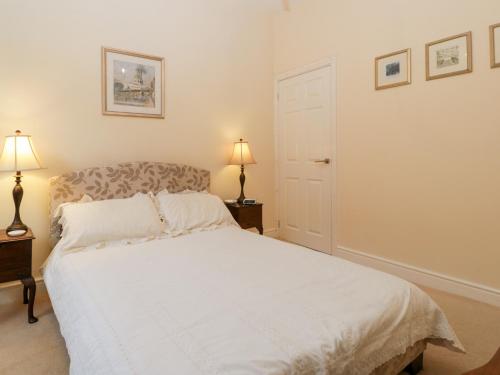 a white bed in a bedroom with two lamps at 138D Old Star & Garter Mews in Ludlow