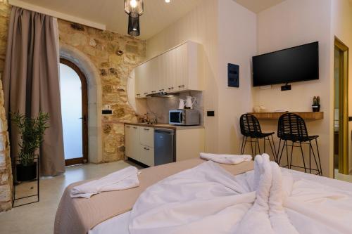 um quarto com uma cama e uma cozinha com uma televisão em Teo Apartments em Georgioupolis