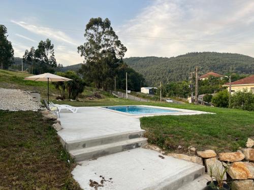 a swimming pool in a yard with an umbrella at Casa Santa Ana in Pontevedra