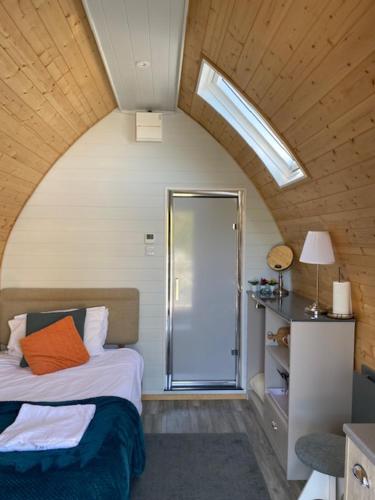 a bedroom with a bed and a glass shower at The Midi Pod in Aberystwyth
