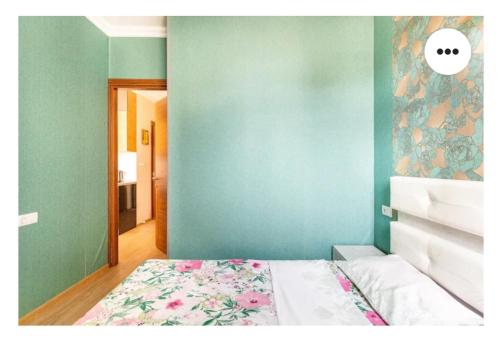 a bedroom with a bed and a blue wall at 1BR Cozy apartment in Batumi