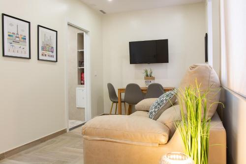 a living room with a couch and a flat screen tv at AP HOTEL NAVAS in Alicante