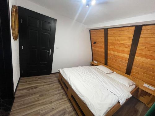 - une chambre avec un grand lit et une porte noire dans l'établissement Moldav-A Frame, à Câmpulung Moldovenesc