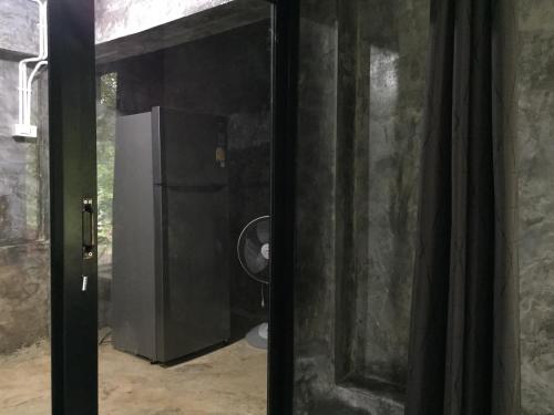 a door leading into a room with a refrigerator at ชลลดา ริเวอร์ โฮมสเตย์ แก่งกระจาน in Ban Wang Malako