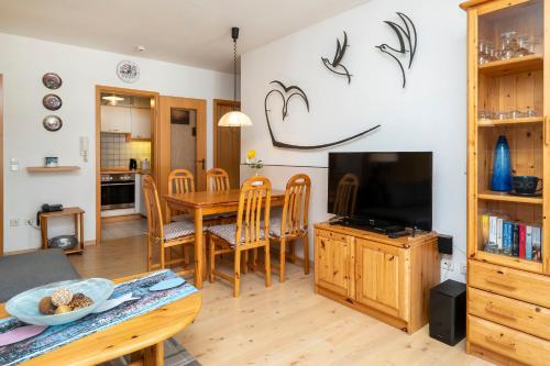 a kitchen and dining room with a table and a television at Ferienpark Freesenbruch Wohnung 1 5 - Amber in Zingst