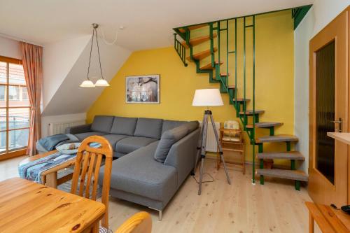 un soggiorno con divano e una scala a chiocciola di Ferienpark Freesenbruch Wohnung 1 5 - Amber a Zingst