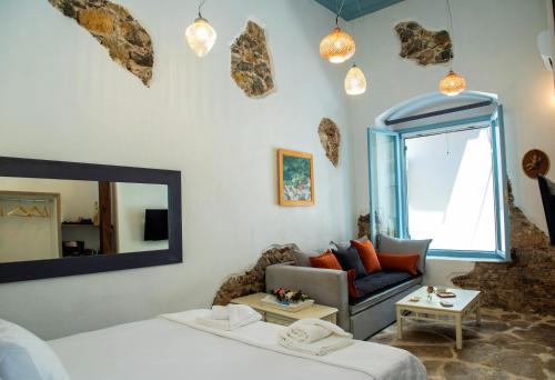 una camera con letto, divano e specchio di Margietta's Suites Nafplio a Nauplia
