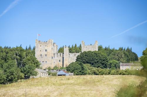 a castle on top of a hill with trees at Knights Rest in Redmire