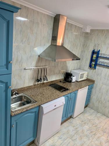 a kitchen with blue cabinets and a sink at Apartamentos La Posada de Abanillas in Abanillas
