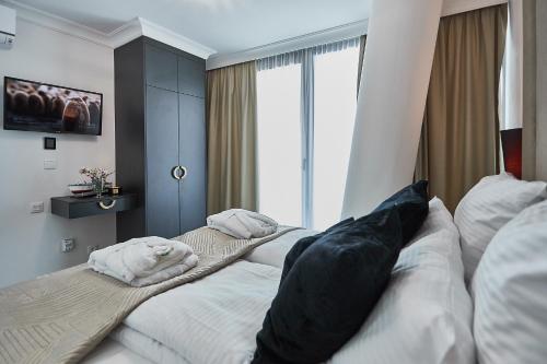 een slaapkamer met 2 bedden en een groot raam bij Wave SPA Gold Apartment in Międzyzdroje