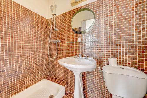 a bathroom with a sink and a toilet and a mirror at Hôtel Robespierre Ex Idéal hôtel Paris - Montreuil in Montreuil