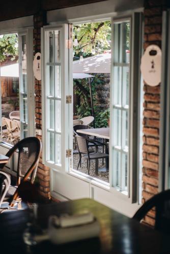 a room with two windows and tables and chairs at Hotel Chateau Kvareli in Kvareli