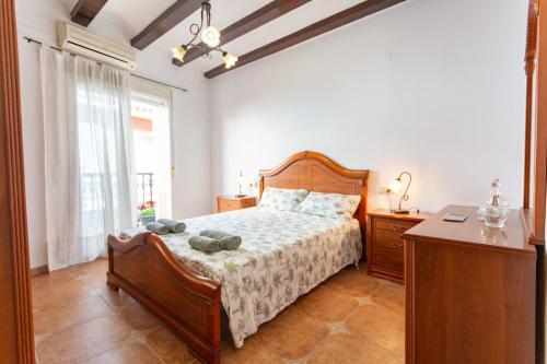 1 dormitorio con cama, escritorio y ventana en Casa Los Geranios, en Cullera