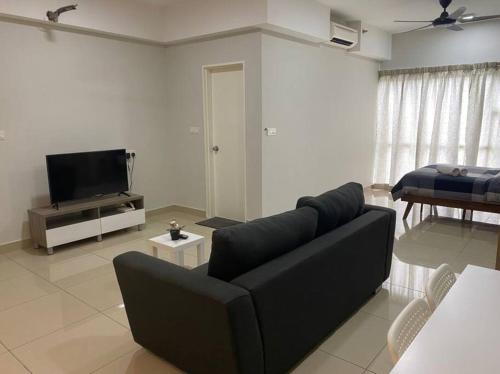 uma sala de estar com um sofá preto e uma televisão em HA12 Cyberjaya, Netflix, Wifi, Free Parking, 3023 em Cyberjaya