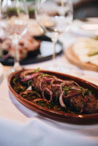 a plate of food on a table with wine glasses at Hotel Chateau Kvareli in Kvareli