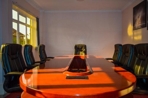 a conference room with a wooden table and chairs at Aberdare Prestige & Royal Cottages in Nanyuki
