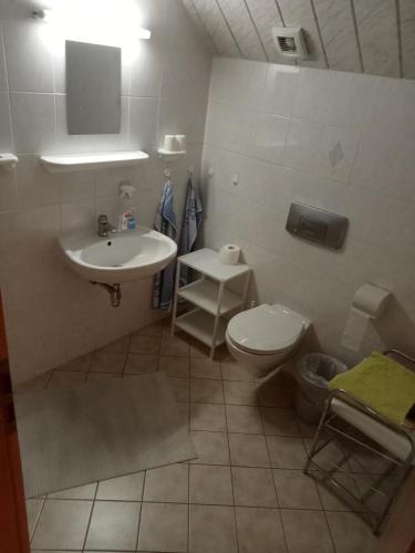 y baño con lavabo y aseo. en Übernachtungszimmer 1, en Schlettau