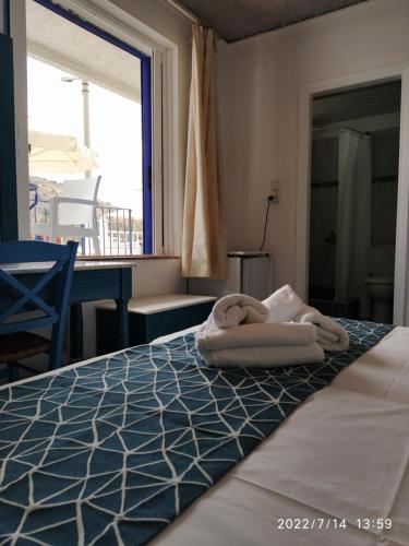 a hotel room with a bed with towels on it at Knossos Hotel in Tolo