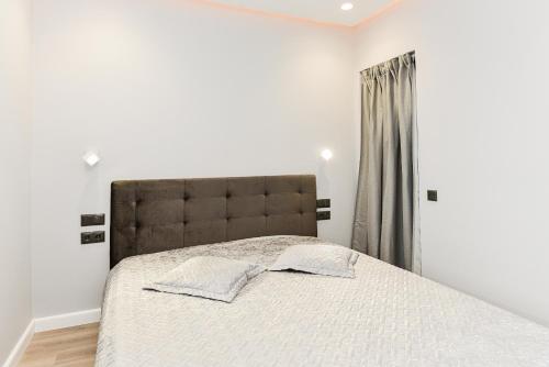 Un dormitorio con una cama grande y una ventana en Apartamentai centre pas Lina en Nida