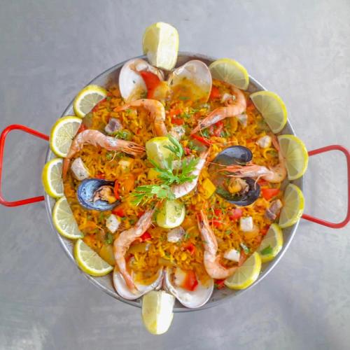 a pan of food with shrimp and vegetables on a table at Prestige Hotel & Spa in Tetouan