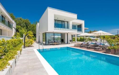 a villa with a swimming pool in front of a house at 270 Panorama Kvarner in Opatija