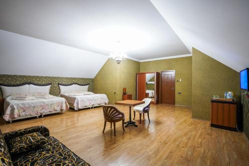 a hotel room with two beds and a table and chairs at Natali Hotel in Borjomi
