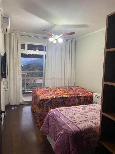 Ένα ή περισσότερα κρεβάτια σε δωμάτιο στο Cobertura 3 dormitórios, 2 vagas, churrasqueira, Wi-fi free, Lázaro Ubatuba