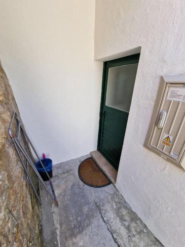 a green door of a building with a step leading to it at Apartman Mediteran in Herceg-Novi