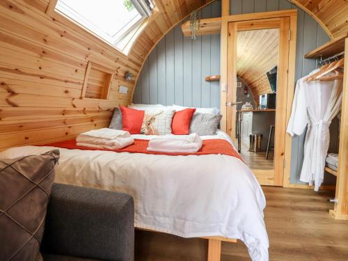 um quarto com uma cama grande num quarto de madeira em Jackdaws Den em Lancaster