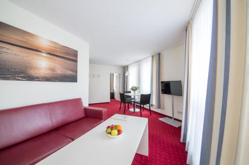 a living room with a couch and a table at Michels Strandhotel Germania in Norderney