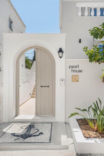 a white house with a door with a sign that reads pearl house at Pearl House - Luxurious new beach villa in Spetses stunning view in Spetses
