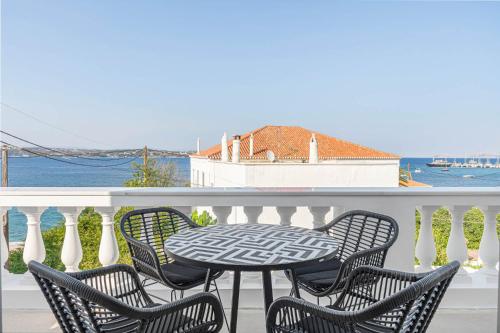 a table and chairs on a balcony with a view of the water at Pearl House - Luxurious new beach villa in Spetses stunning view in Spetses