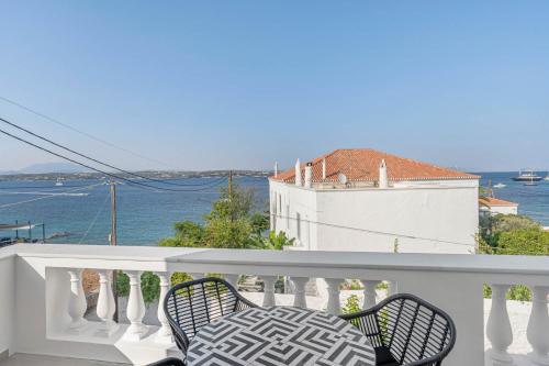 a table and chairs on a balcony with the ocean at Pearl House - Luxurious new beach villa in Spetses stunning view in Spetses