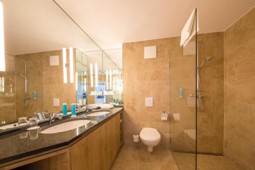 a bathroom with two sinks and a shower at Michels Strandhotel Germania in Norderney