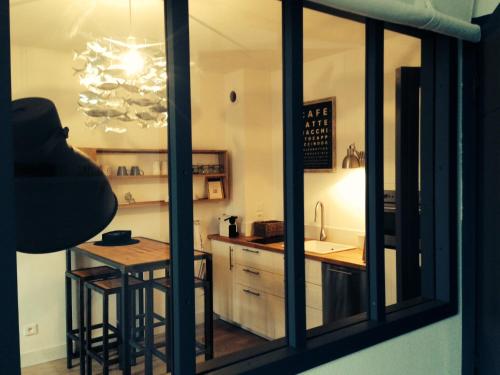 - une cuisine avec un comptoir, une table et un évier dans l'établissement L' Appart du Marché, à La Rochelle
