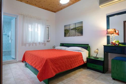 1 dormitorio con 1 cama con colcha roja en Villa Isabella, en Toroni