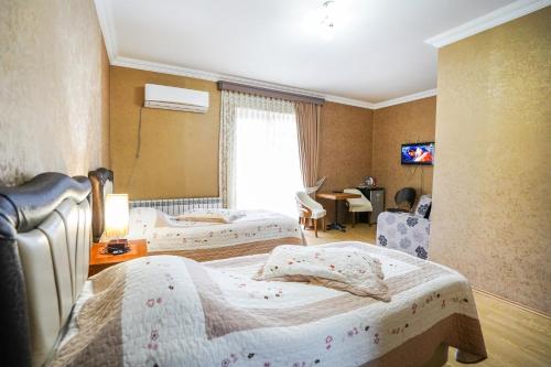 a hotel room with two beds and a table at Natali Hotel in Borjomi