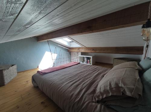 a bedroom with a large bed in a attic at GiTE ATYPIQUE AVEC PISCINE COUVERTE en saison in St Apollinaire De Rias