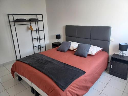 a bedroom with a large bed with a red blanket at Maison Face au Mont avec extérieur in Avranches