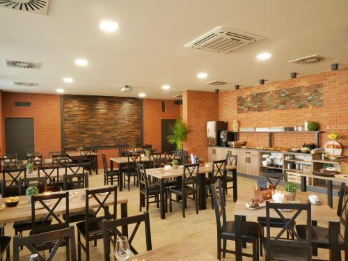 a restaurant with tables and chairs and a kitchen at DELUXE Rožnov in Rožnov pod Radhoštěm