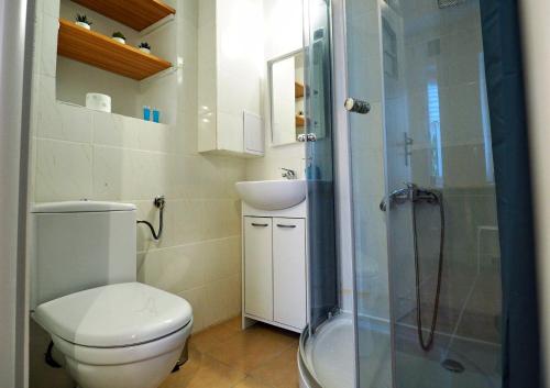 a bathroom with a toilet and a sink and a shower at Wiślna 4 by Homeprime in Krakow
